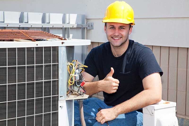 HVAC technician next to equipment